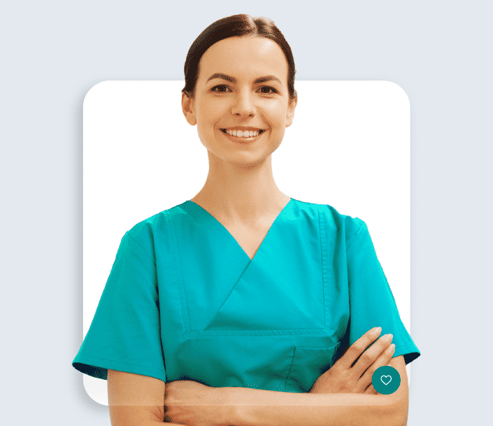 Asistent medicală generalistă care zâmbește, are părul prins, stă cu mâinile încrucișate și poartă un costum verde de asitenți